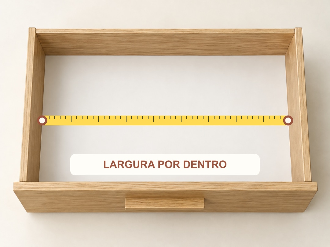 Largura: a fita atravessa o interior da gaveta de uma parede interna à outra. Dois círculos marcam onde a medida começa e termina.